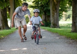 9878745-father-teaching-his-son-to-ride-a-bike