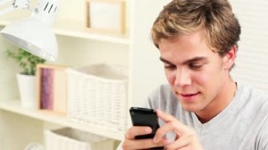 stock-footage-joyful-young-man-using-mobile-phone-sending-text-message