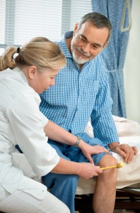 Physician checking reflexes of an old man