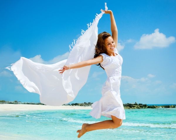 Beautiful Girl With White Scarf Jumping on The Beach