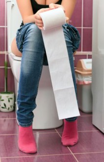 Woman in a toilet with a big hank of sanitary paper