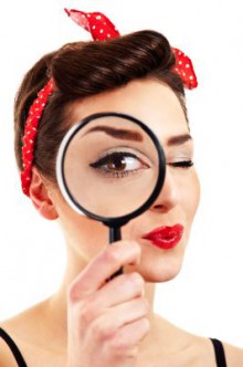 Woman with magnifier on white background