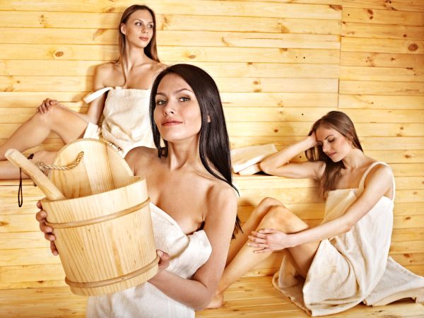 Group people relaxing in sauna.