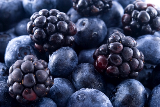 Close up of blueberries and blackberries in a pile