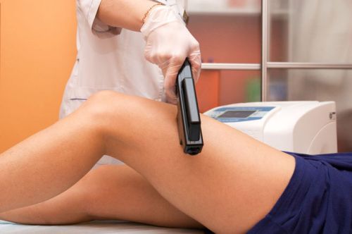 Laser epilation of leg in a modern beauty shop