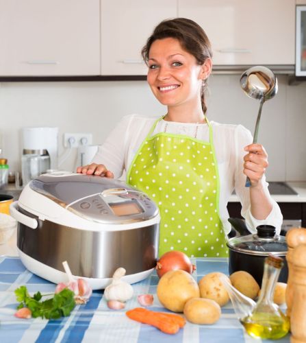 Happy woman using new slo-cooker at home