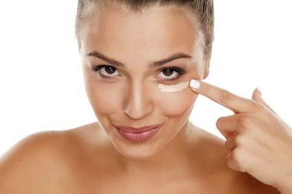 young woman apply concealer under the eye