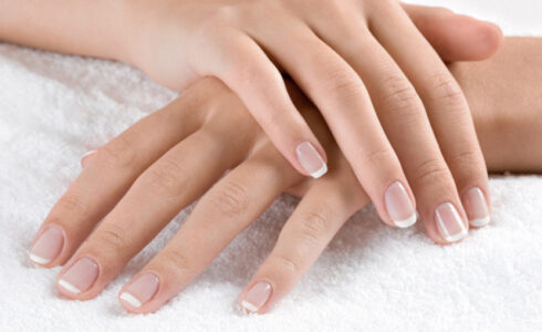 Nice hands on white towel. Soft manicure.
