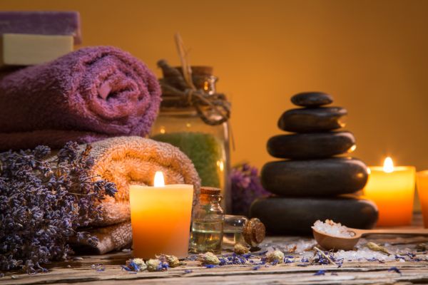 Spa still-life with stacked of stone and burning candles, close-up.