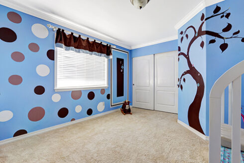 Beautiful baby room interior with cheerful murals on bright blue walls