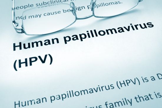 Paper with words HPV infection and glasses.
