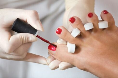 A photo of pedicure process - nail polishing.