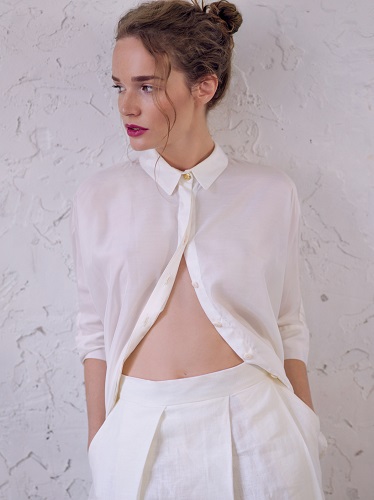 Girl in a long white shorts and white shirt. Fashion studio shot