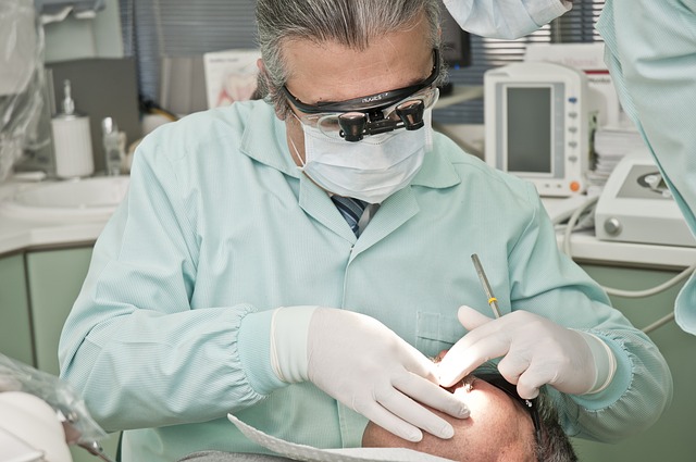 Stomatolog wykonujący zabieg dentystyczny.