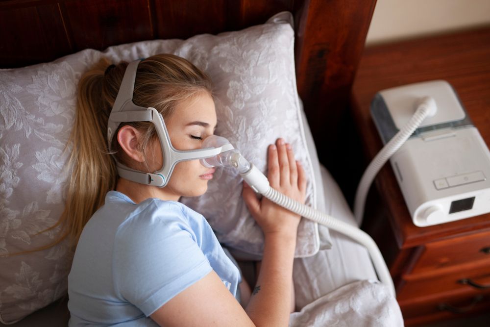 Kobieta śpiąca z&nbsp;maszyną CPAP